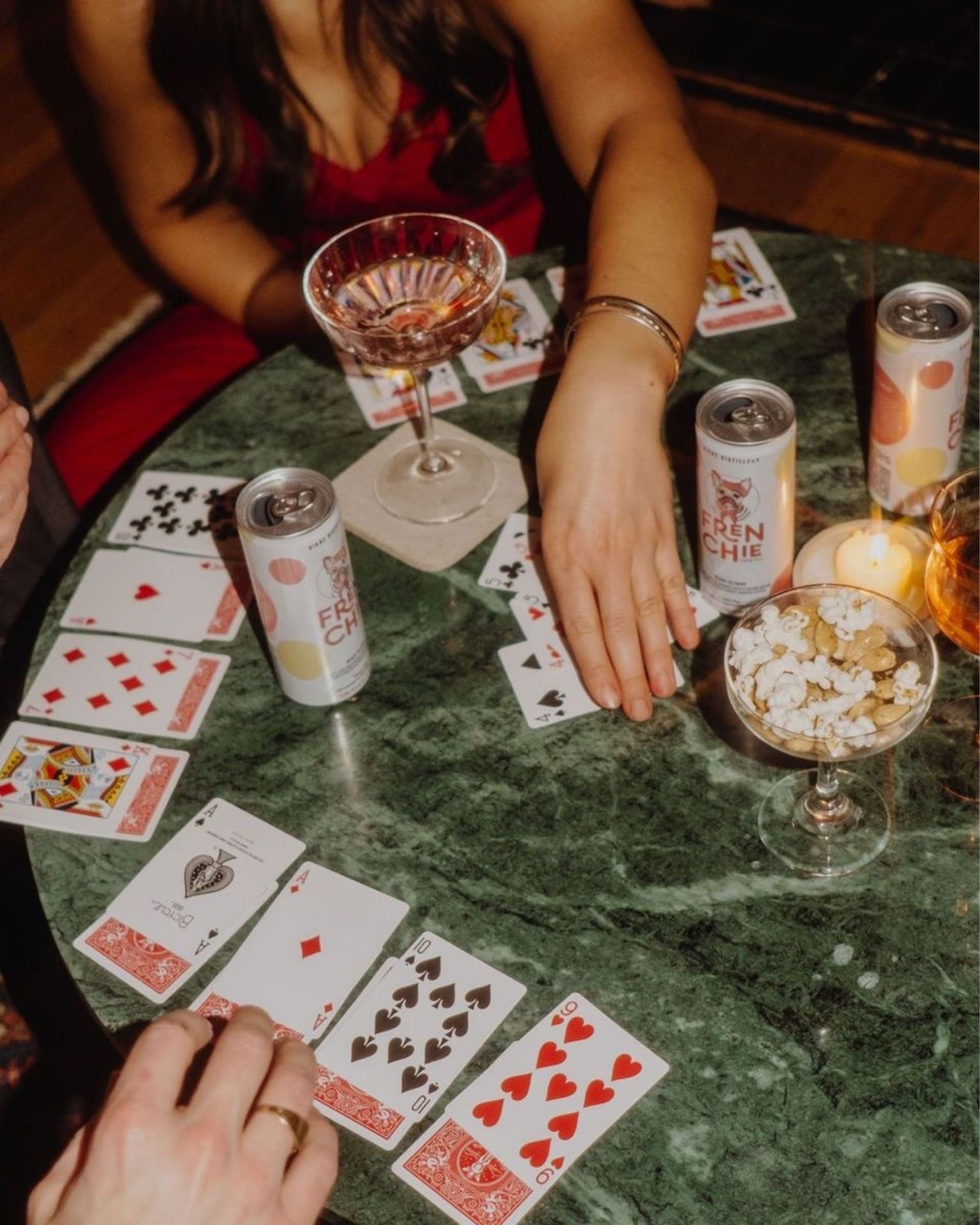 Kartenspiel auf einem grünen Marmortisch mit Drinks und Popcorn